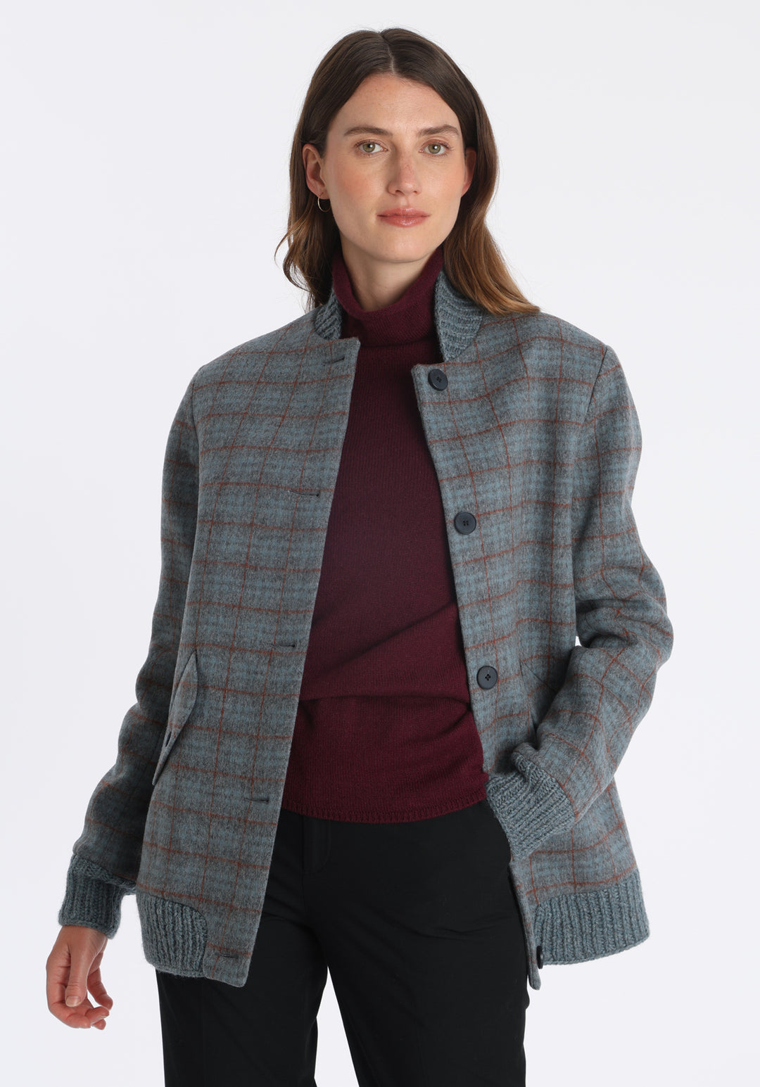 Model wearing the Jeffy jacket in silver blue and rust check merino wool, a baseball-inspired style with curved pocket flaps, front button fastenings, and ribbed knit trim, cut in a streamlined silhouette.