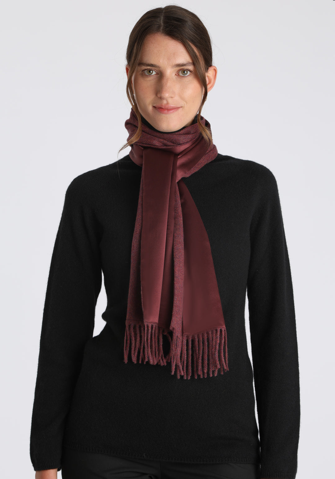 Model wearing the shiraz marl cashmere scarf backed with burgundy silk, over a black cashmere jumper.