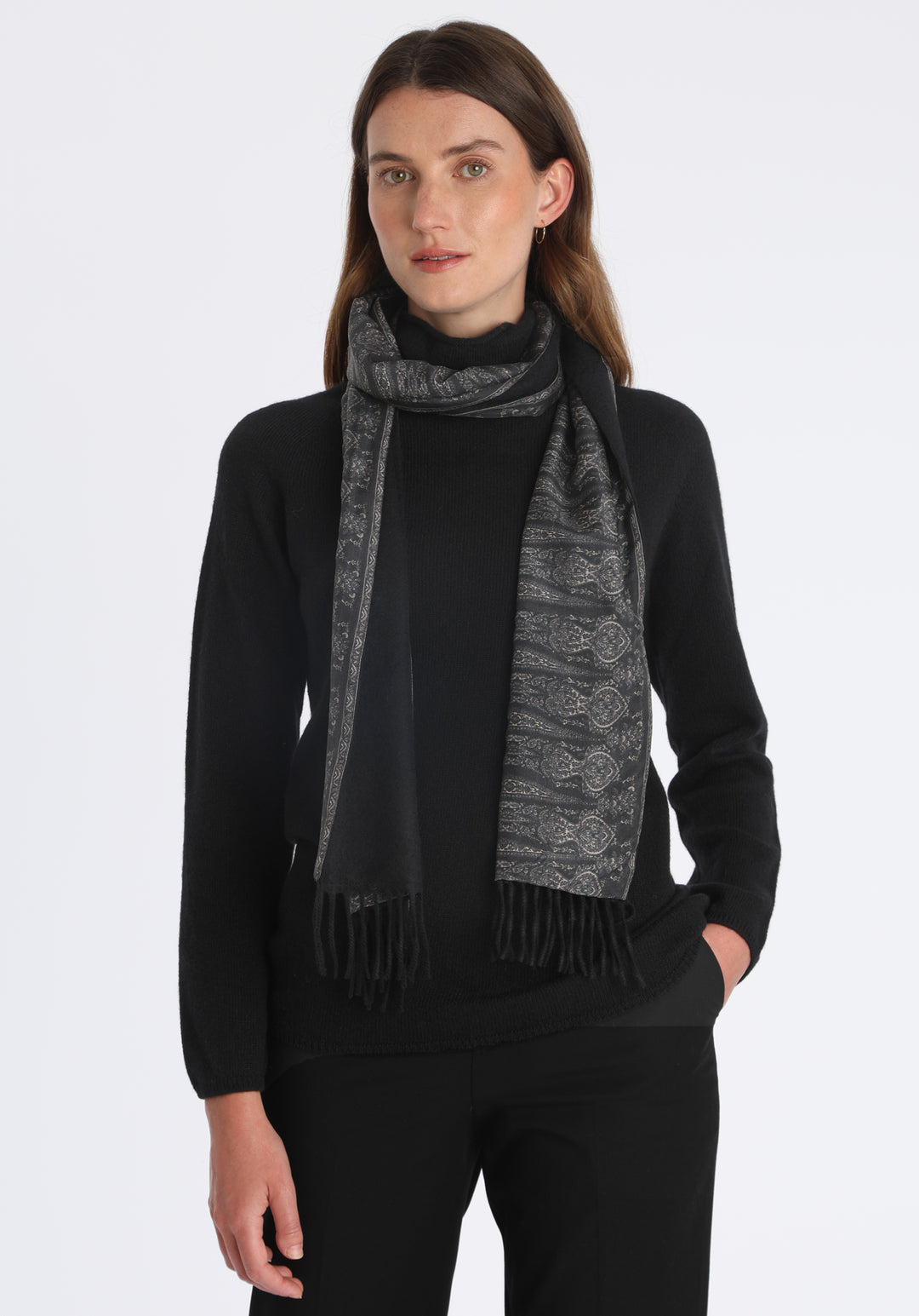 Model wearing the black cashmere scarf backed with charcoal paisley printed silk, over a black cashmere jumper.