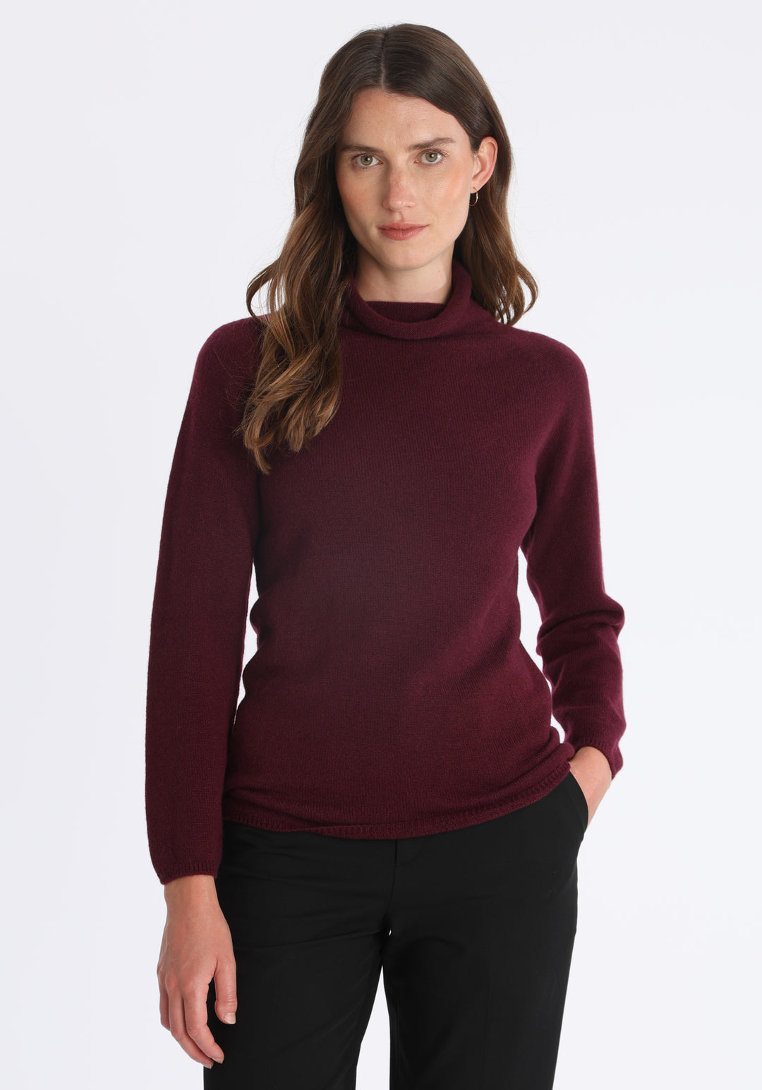 Model wearing the fine-knit cashmere jumper in shiraz, a slim fit style with a draped high neck, designed for layering and year-round wear.