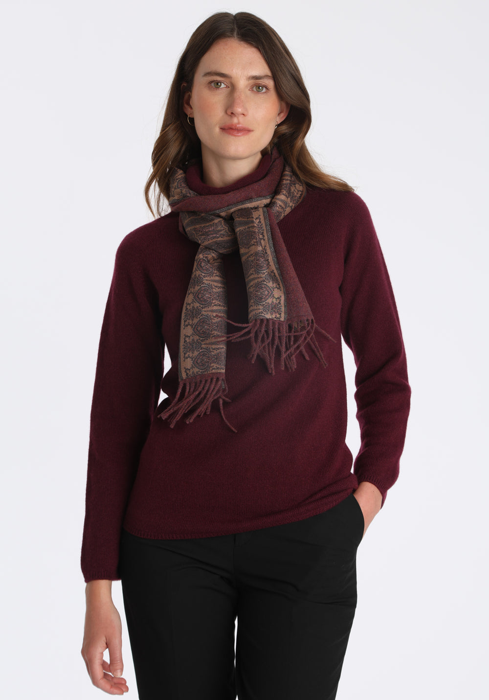 Model wearing the shiraz marl cashmere scarf backed with antique camel paisley printed silk, over a cashmere jumper in shiraz.