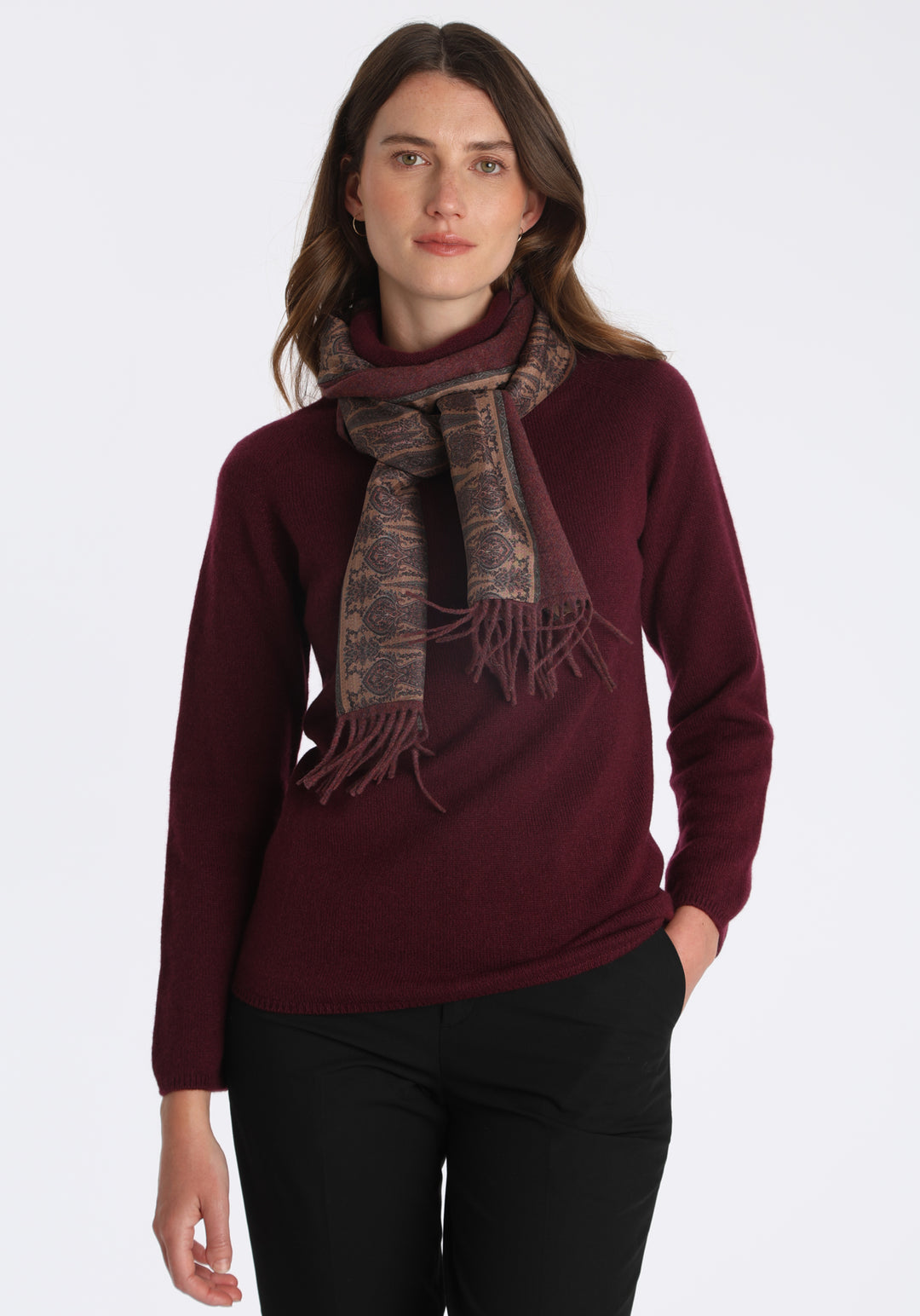 Model wearing the shiraz marl cashmere scarf backed with antique camel paisley printed silk, over a cashmere jumper in shiraz.