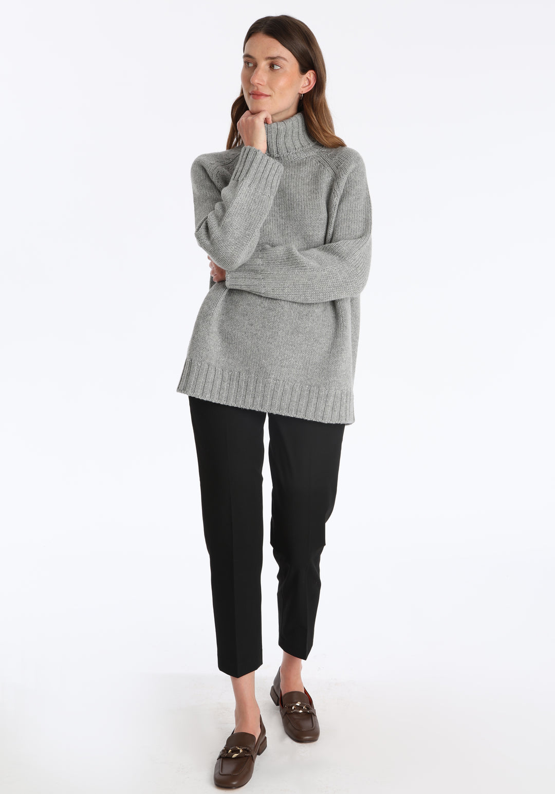 Model wearing the chunky roll neck jumper in grey marl Scottish cashmere—a one-size knit with dropped shoulders, ribbed trims, and a softly structured silhouette.
