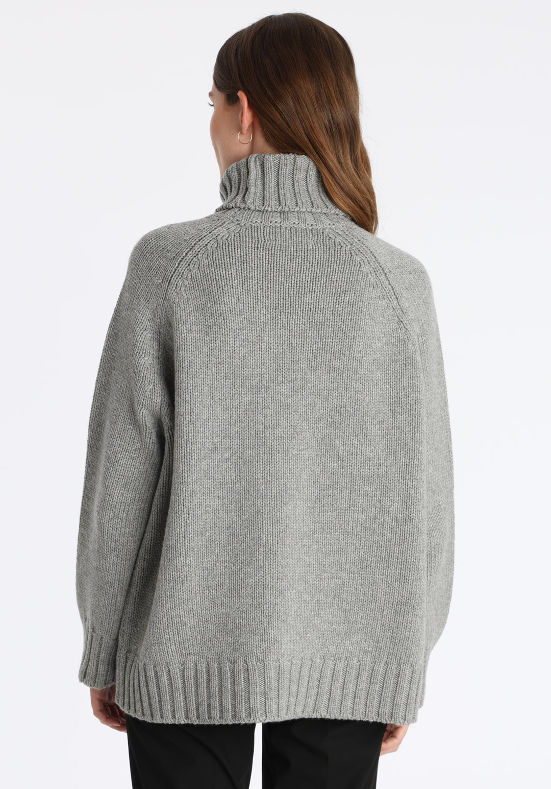 Model wearing the chunky roll neck jumper in grey marl Scottish cashmere—a one-size knit with dropped shoulders, ribbed trims, and a softly structured silhouette.
