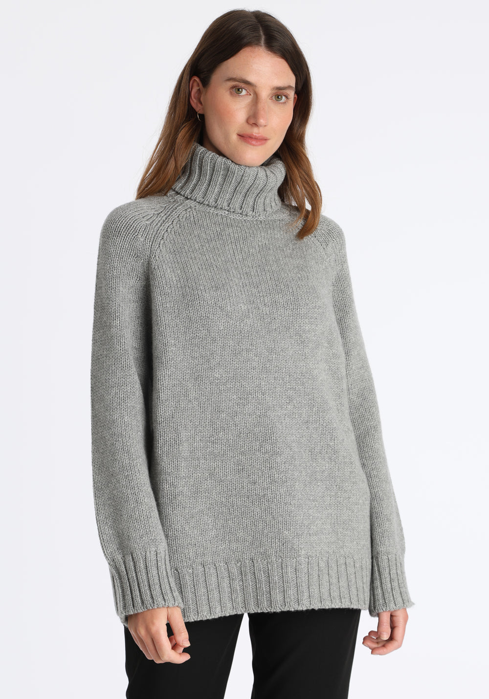 Model wearing the chunky roll neck jumper in grey marl Scottish cashmere—a one-size knit with dropped shoulders, ribbed trims, and a softly structured silhouette.