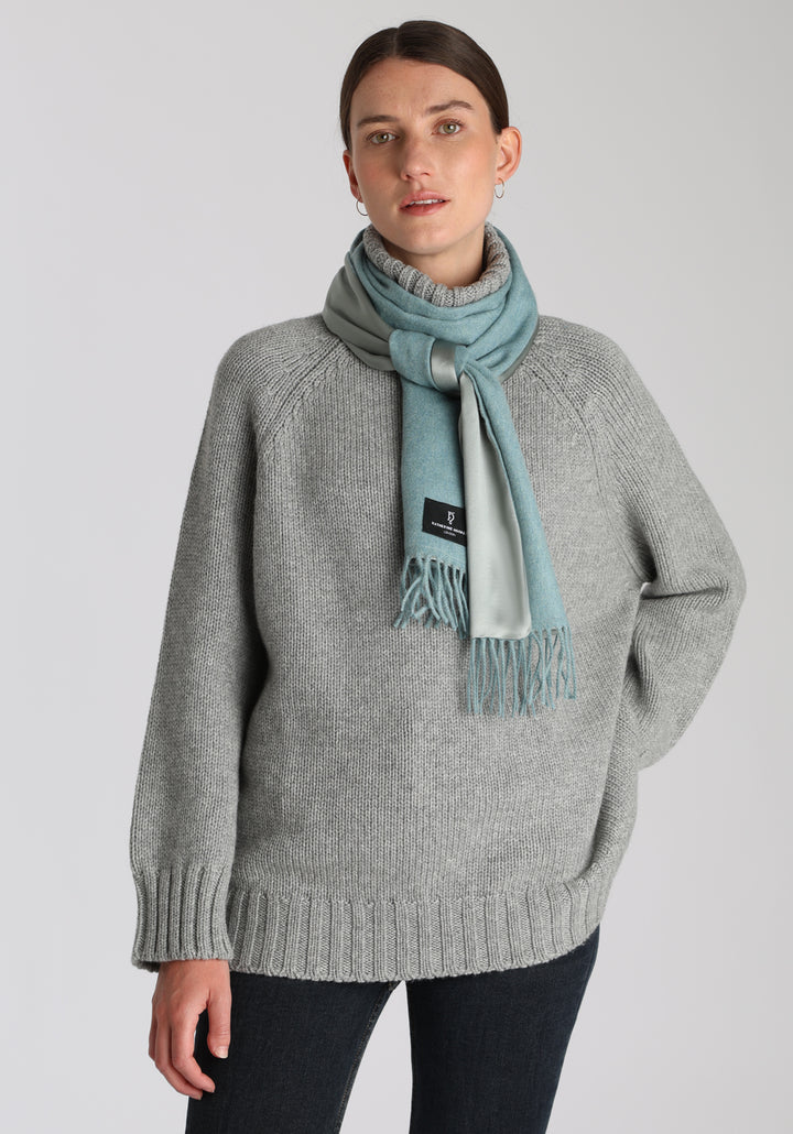 Model wearing the chunky roll neck jumper in grey marl Scottish cashmere—a one-size knit with dropped shoulders, ribbed trims, and a softly structured silhouette.