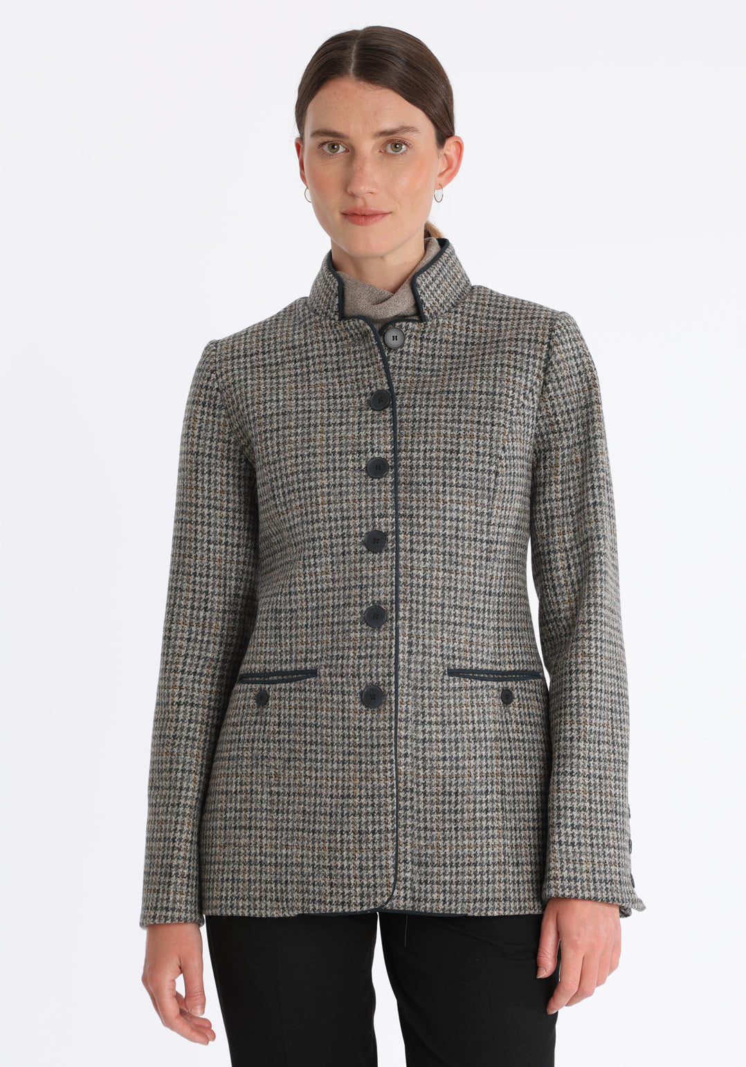 Model wearing the Patmos jacket in stone grey and ochre check with suede trim, a slim-fit style featuring a mandarin collar, front pockets, and generous sleeves with button detailing.