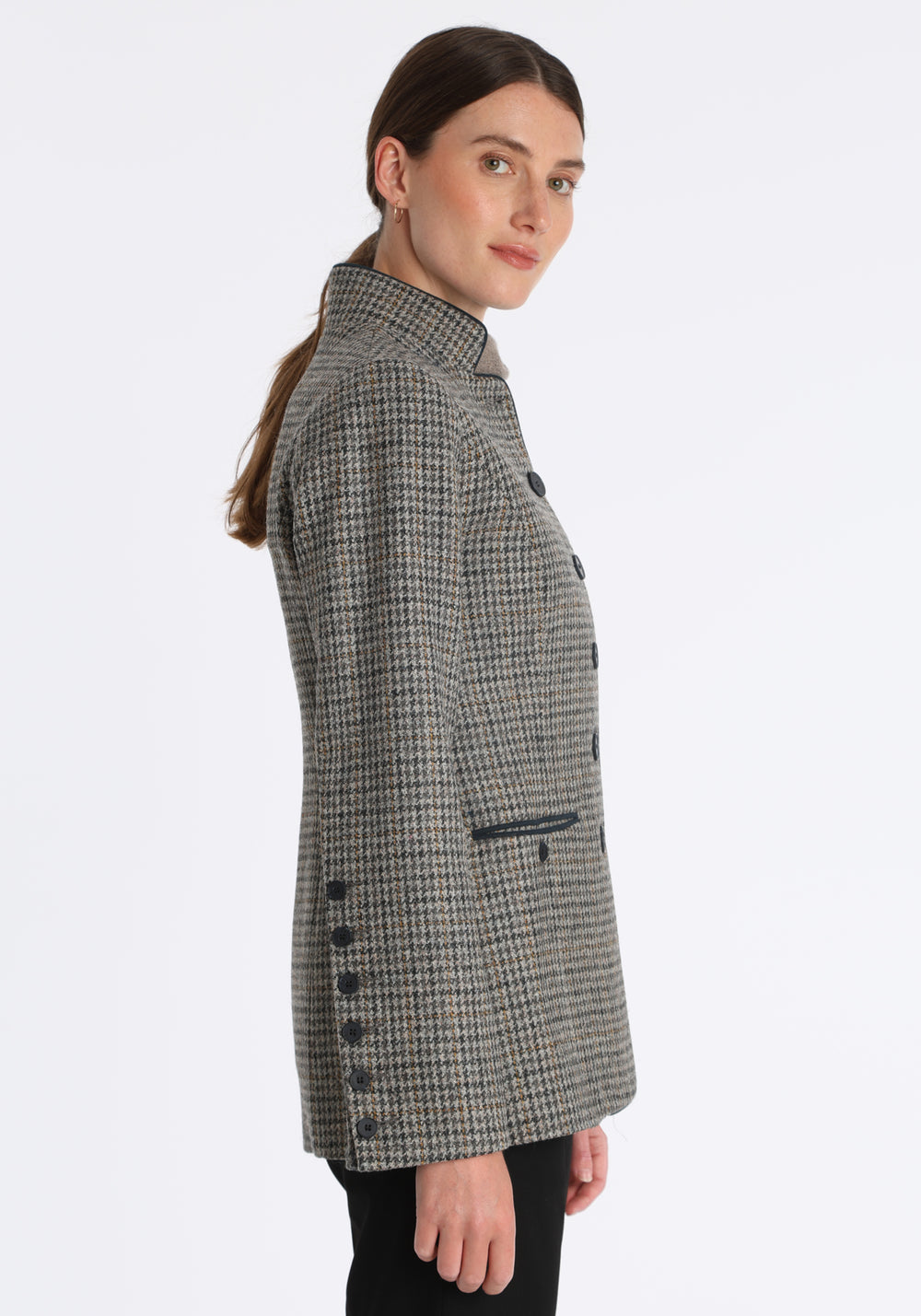 Model wearing the Patmos jacket in stone grey and ochre check with suede trim, a slim-fit style featuring a mandarin collar, front pockets, and generous sleeves with button detailing.