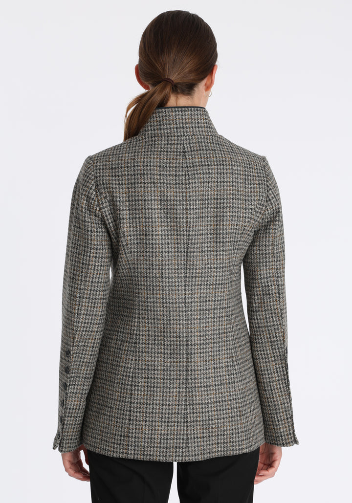 Model wearing the Patmos jacket in stone grey and ochre check with suede trim, a slim-fit style featuring a mandarin collar, front pockets, and generous sleeves with button detailing.