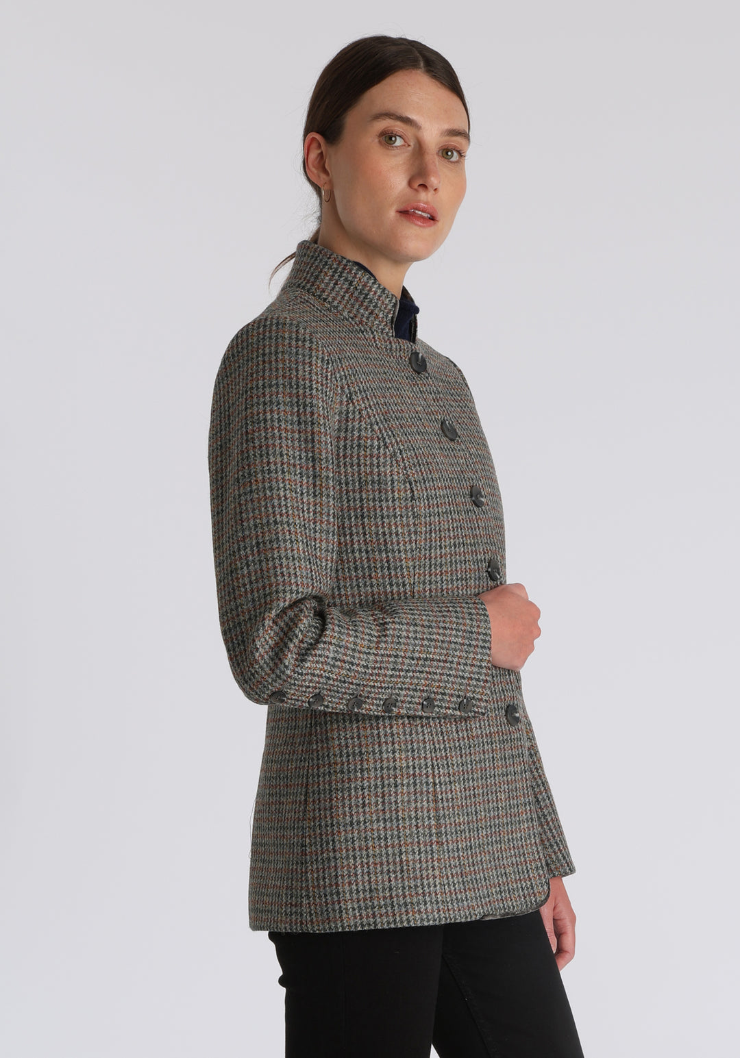 Model wearing the Patmos jacket in autumnal cinder dogtooth check with silk velvet trim, a slim-fit style featuring a mandarin collar, front pockets, and generous sleeves with slate button detailing.