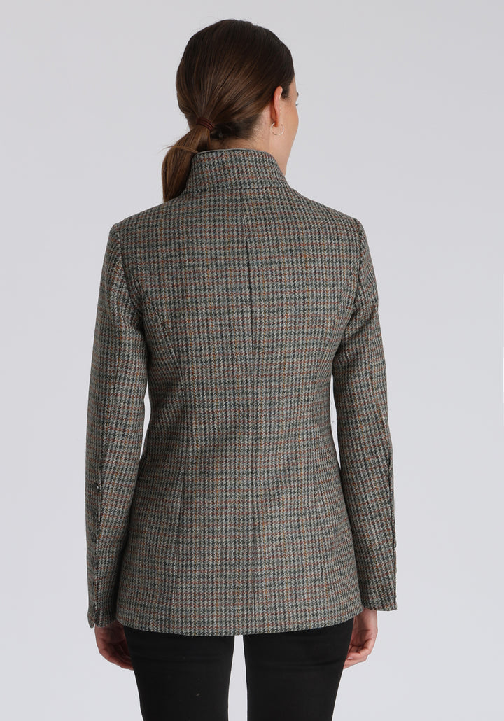 Model wearing the Patmos jacket in autumnal cinder dogtooth check with silk velvet trim, a slim-fit style featuring a mandarin collar, front pockets, and generous sleeves with slate button detailing.