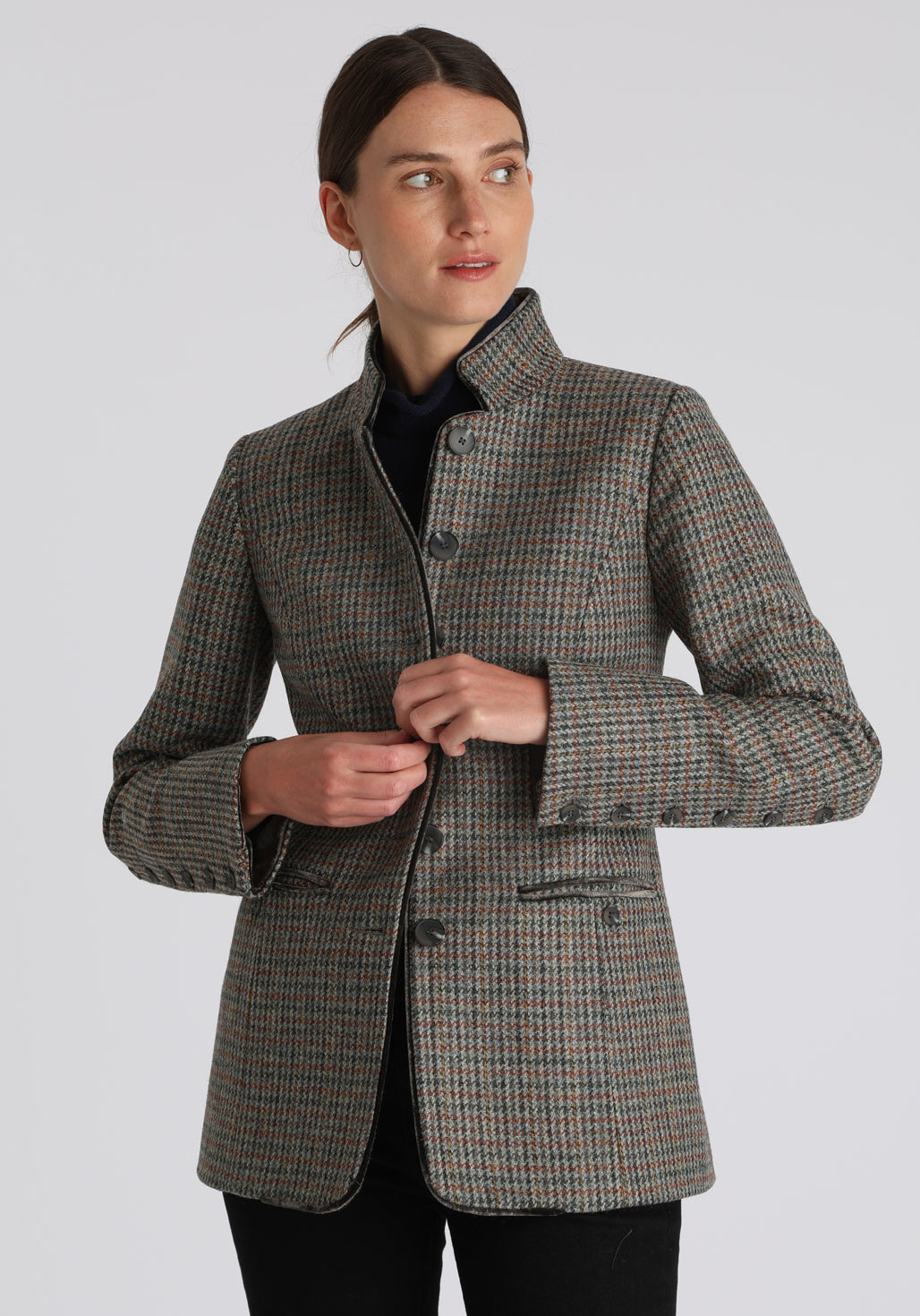 Model wearing the Patmos jacket in autumnal cinder dogtooth check with silk velvet trim, a slim-fit style featuring a mandarin collar, front pockets, and generous sleeves with slate button detailing.