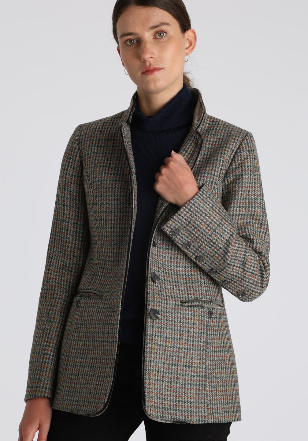 Model wearing the Patmos jacket in autumnal cinder dogtooth check with silk velvet trim, a slim-fit style featuring a mandarin collar, front pockets, and generous sleeves with slate button detailing.