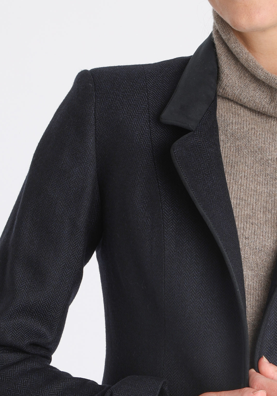 Model wearing the Tallulah jacket in navy herringbone lambswool with suede trim, a tailored style with a single button fastening and a collar that can be worn turned up or down.