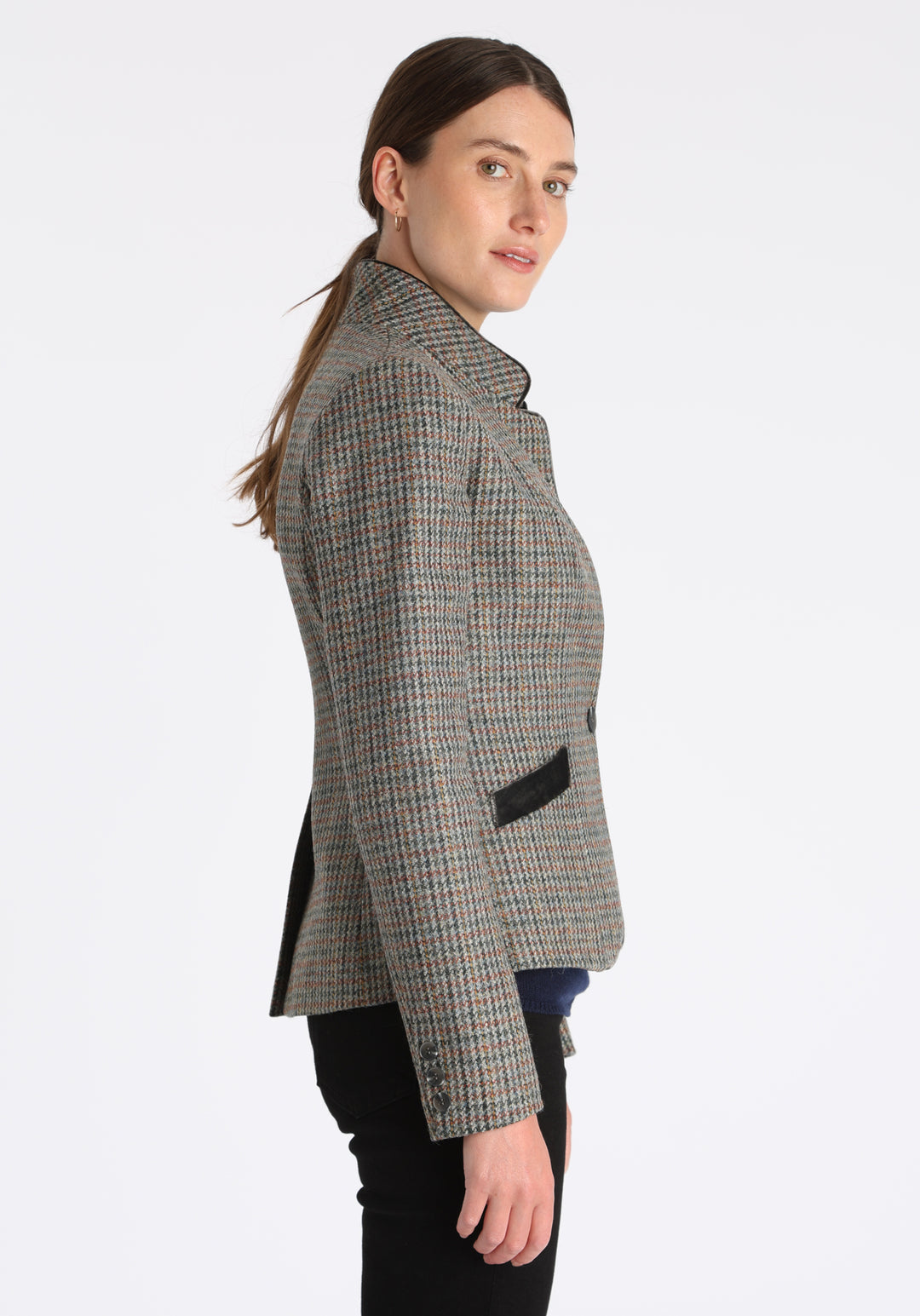 Model wearing the Tallulah jacket in autumnal cinder check with silk velvet trim, a tailored style with a single button fastening and a collar that can be worn turned up or down.