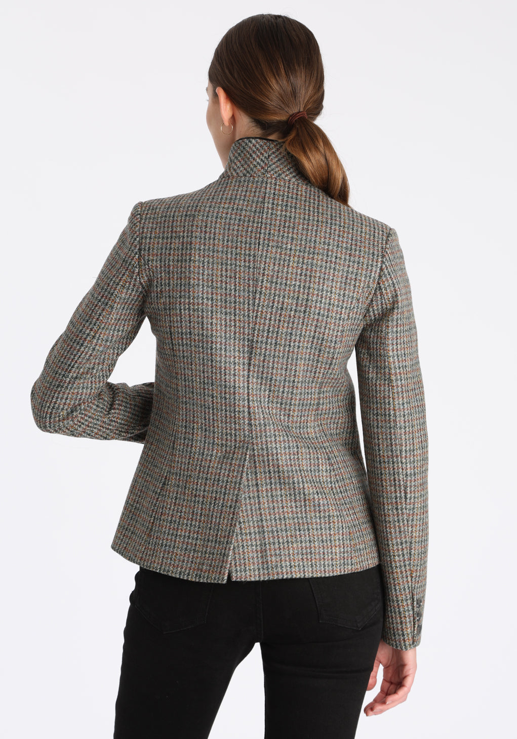 Model wearing the Tallulah jacket in autumnal cinder check with silk velvet trim, a tailored style with a single button fastening and a collar that can be worn turned up or down.