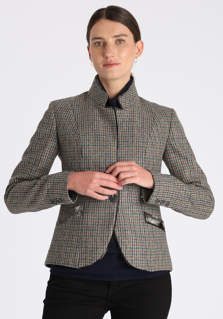 Model wearing the Tallulah jacket in autumnal cinder check with silk velvet trim, a tailored style with a single button fastening and a collar that can be worn turned up or down.