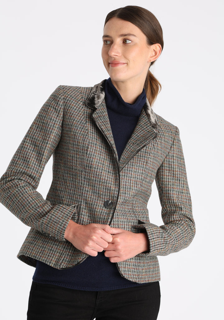 Model wearing the Tallulah jacket in autumnal cinder check with silk velvet trim, a tailored style with a single button fastening and a collar that can be worn turned up or down.