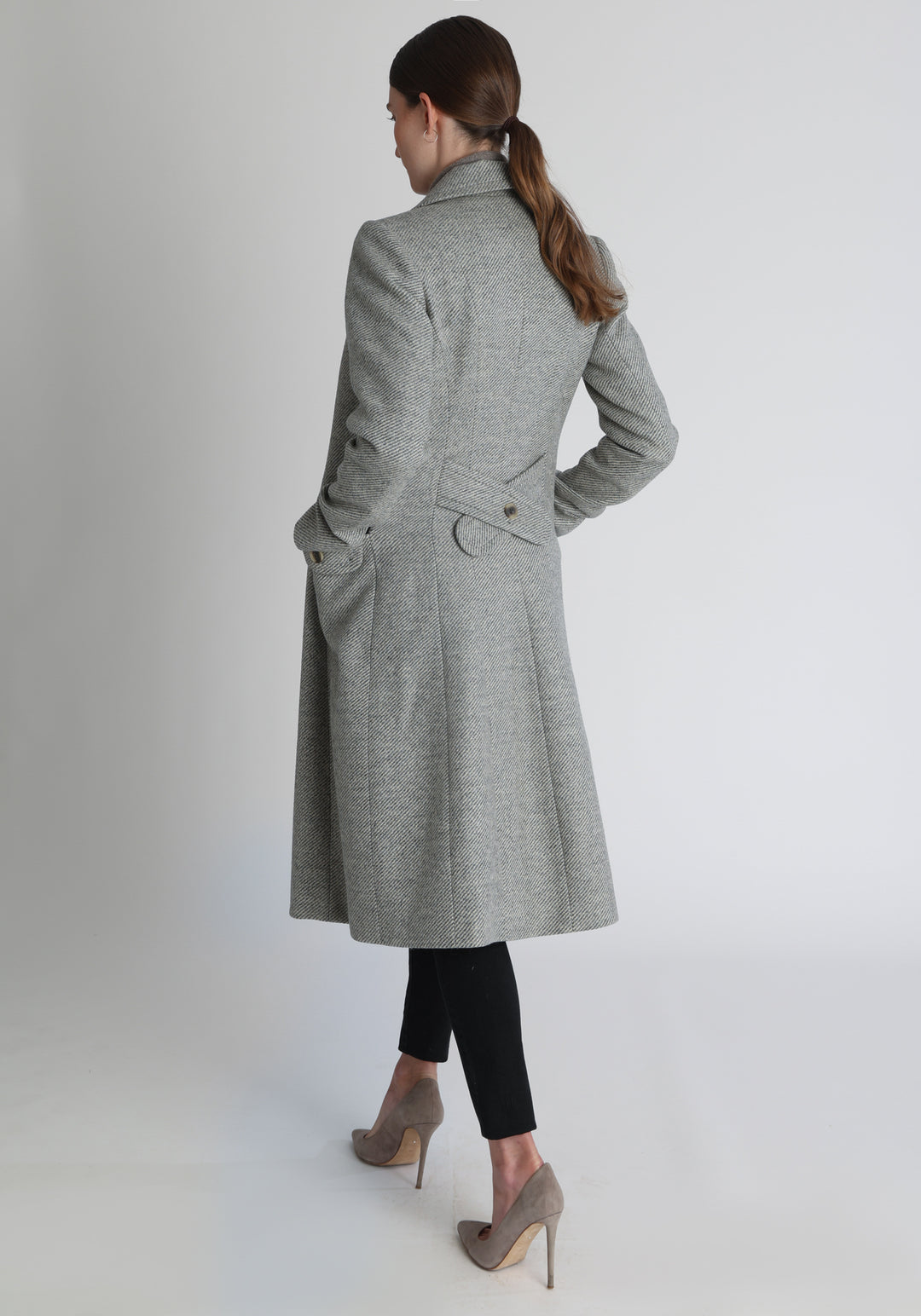 Model wearing the slate blue and cream lambswool twill, a vintage-inspired style with a double-breasted front, gently flared skirt, and curved detailing on the collar, pockets, and back belt.
