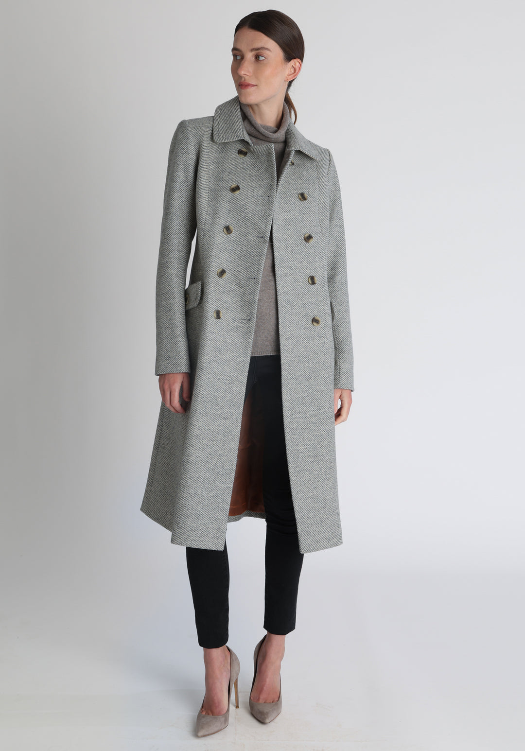 Model wearing the slate blue and cream lambswool twill, a vintage-inspired style with a double-breasted front, gently flared skirt, and curved detailing on the collar, pockets, and back belt.