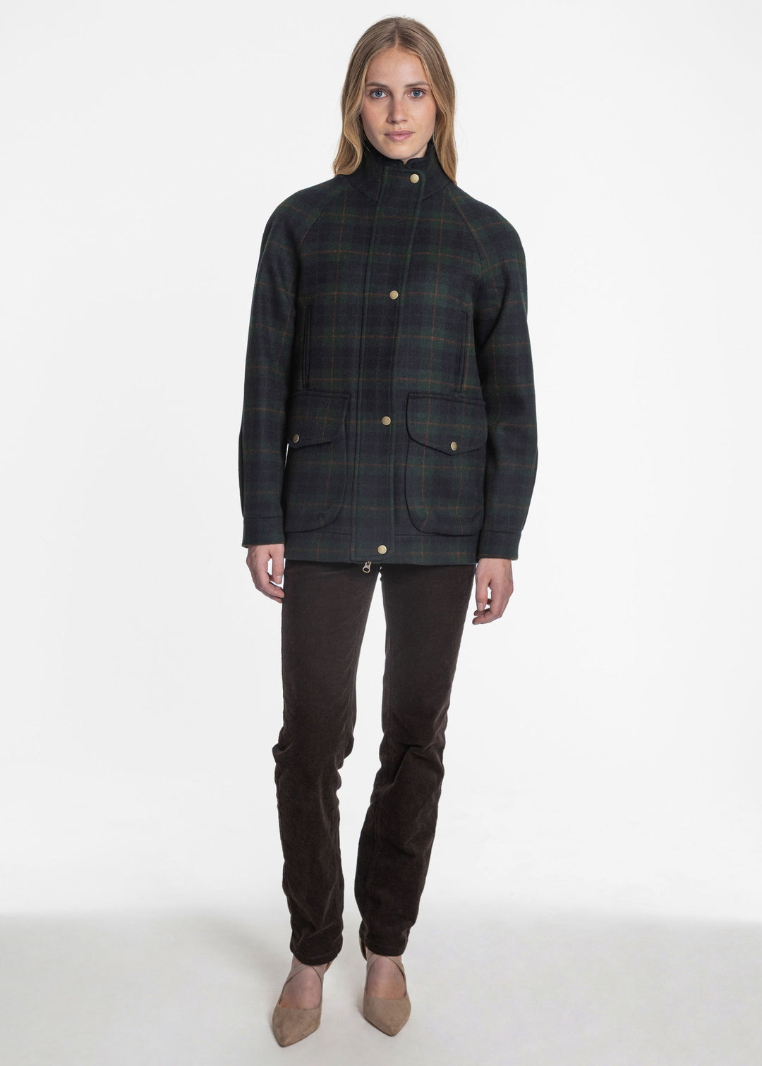 A woman wearing a navy and green plaid jacket with metal snap buttons.