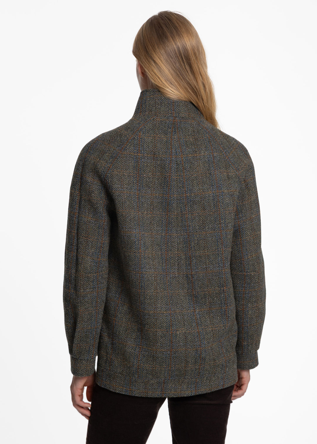 Back of a woman wearing a textured green tweed jacket.