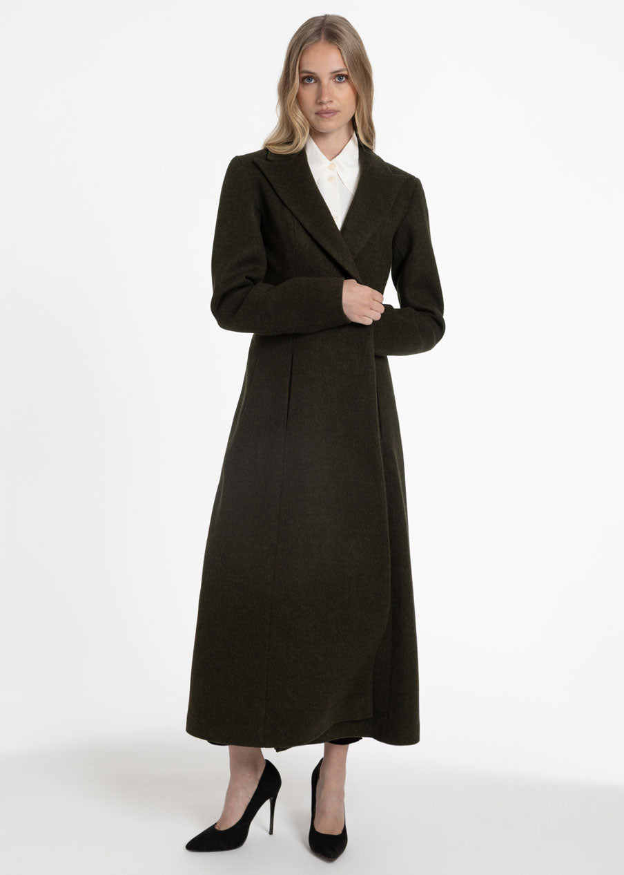 Woman wearing a dark olive green wool coat with a white collared shirt.