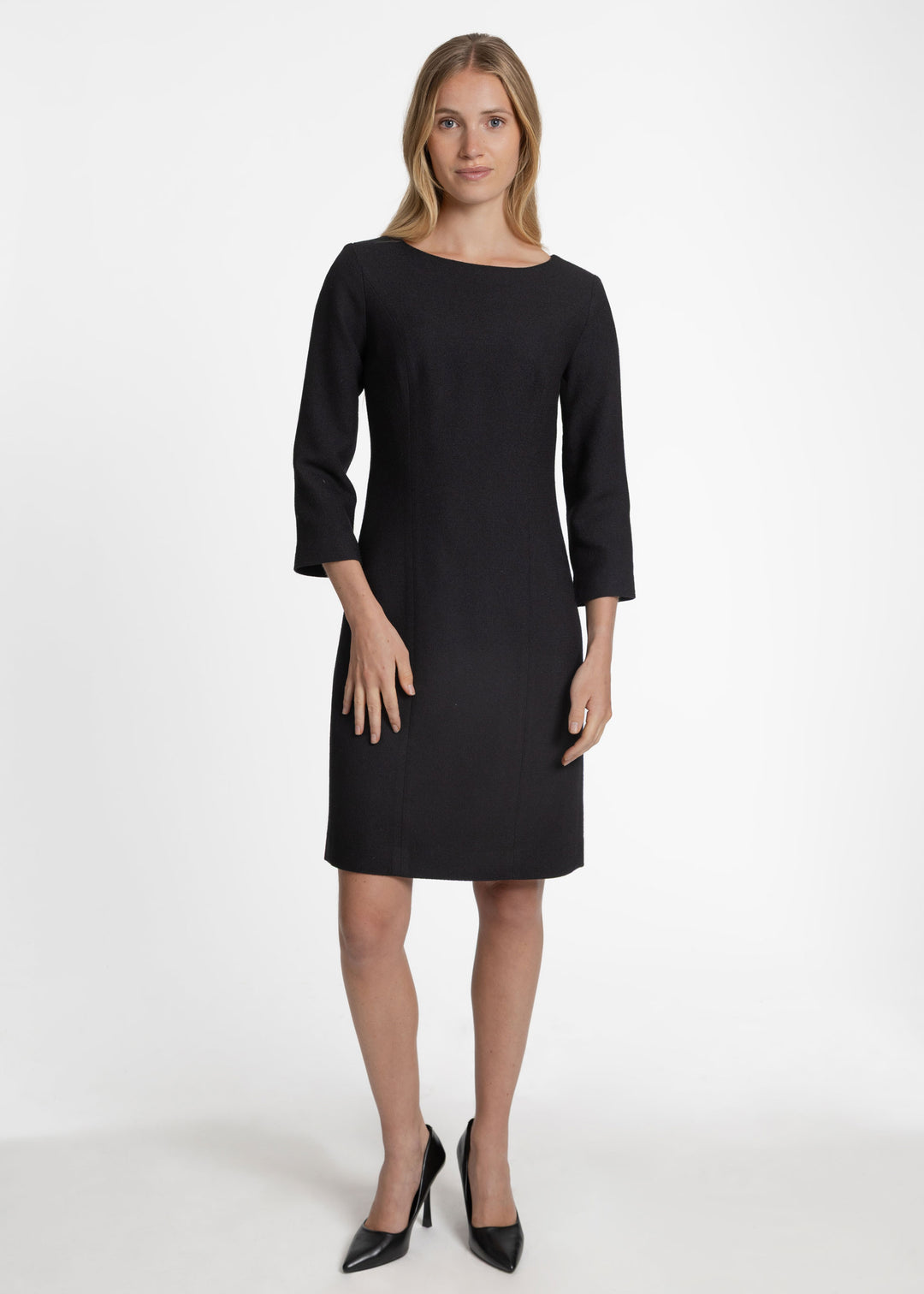 Woman wearing a black 3/4 sleeve knee length dress.