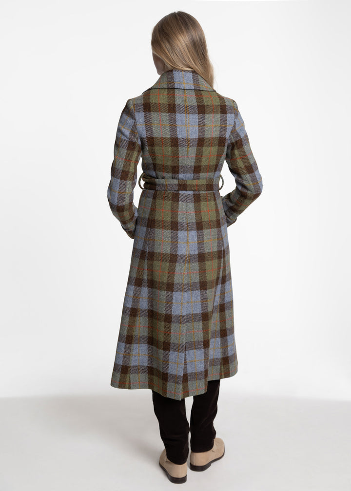 Back view of a woman modeling a brown, blue and green plaid coat with a belt closure.