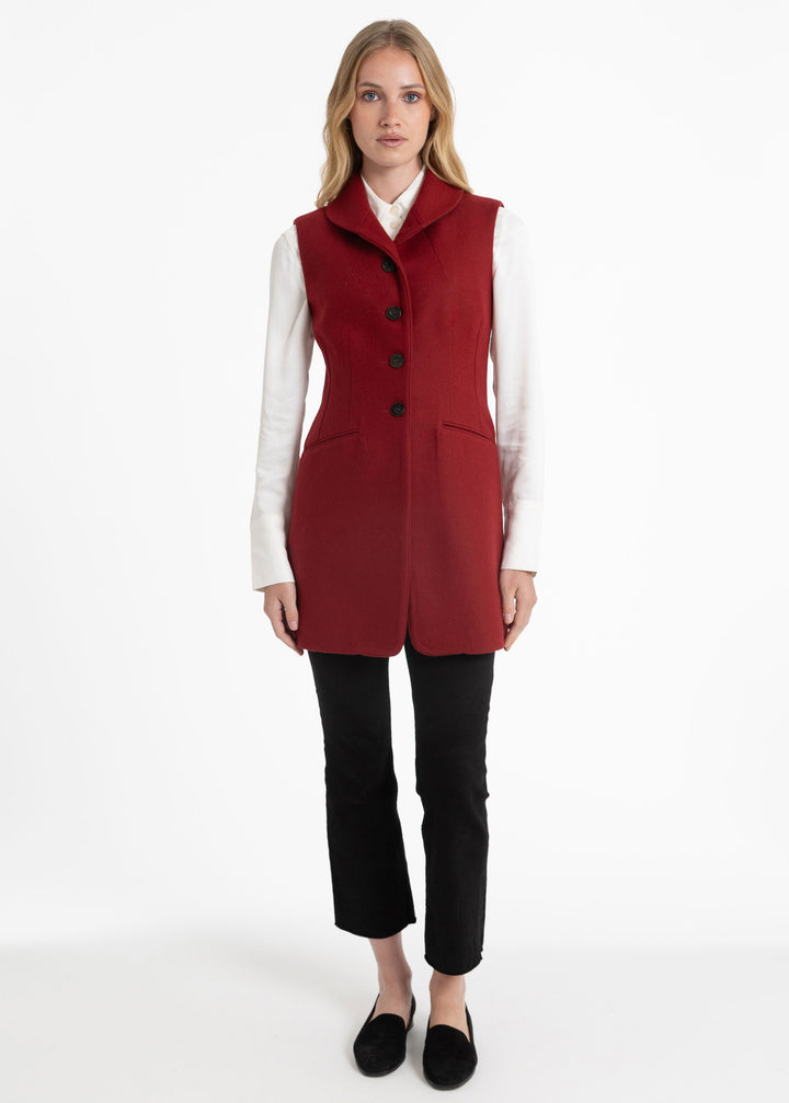 Woman wearing a red waistcoat with a white collared shirt underneath.