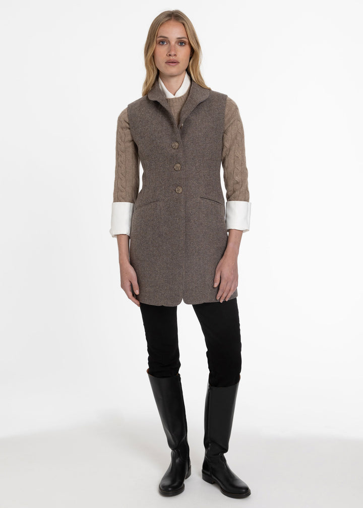 Woman in a heather herringbone wool waistcoat with front brown buttons.