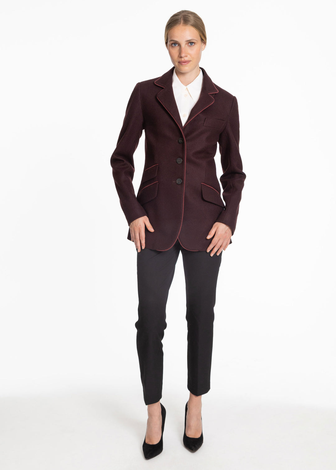 Woman wearing a mulberry jacket with burgundy trim accents. Paired with black trousers and black high heels.