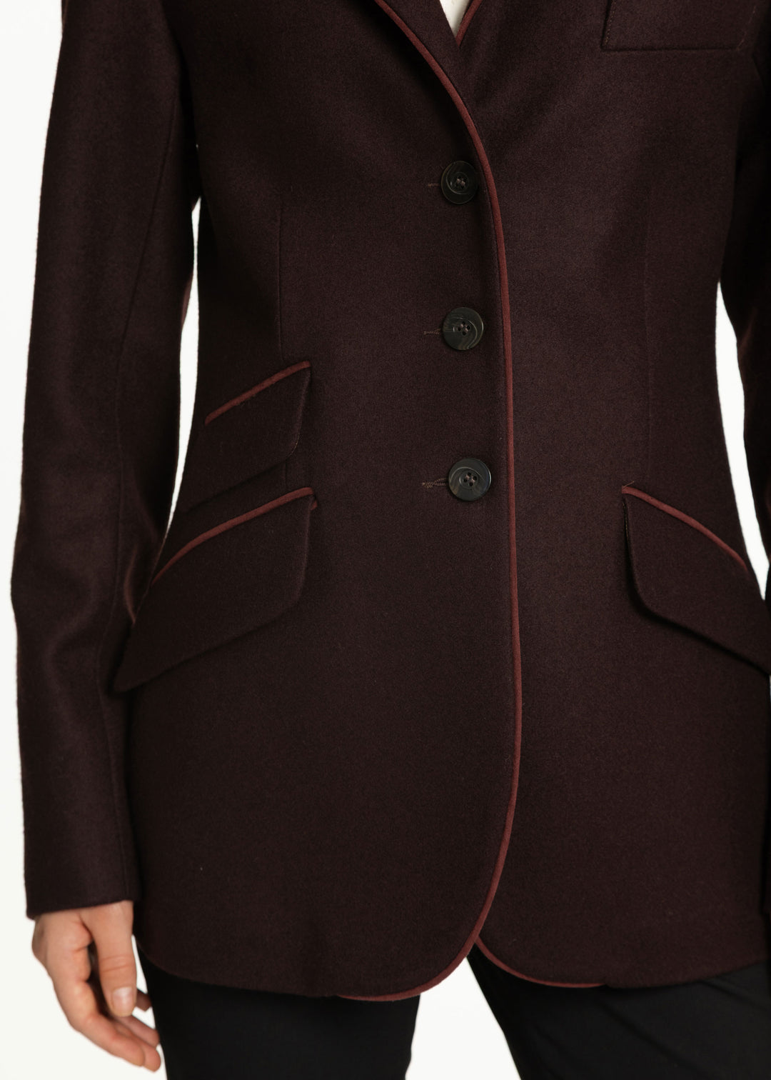 Close up of a woman wearing a wool mulberry jacket with burgundy trim. 
