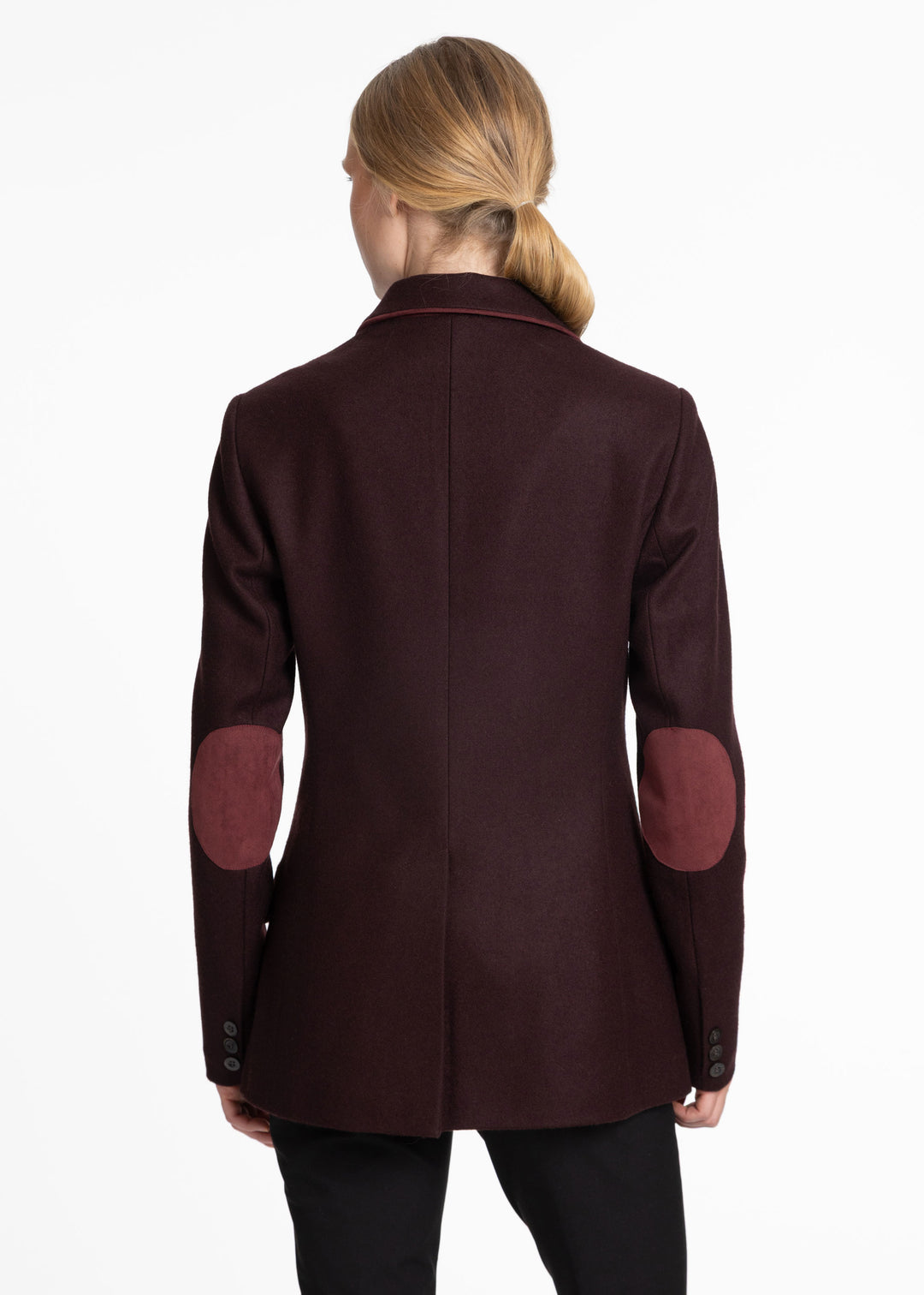 Back view of a woman wearing a mulberry wool jacket with burgundy trim and burgundy elbow patches.