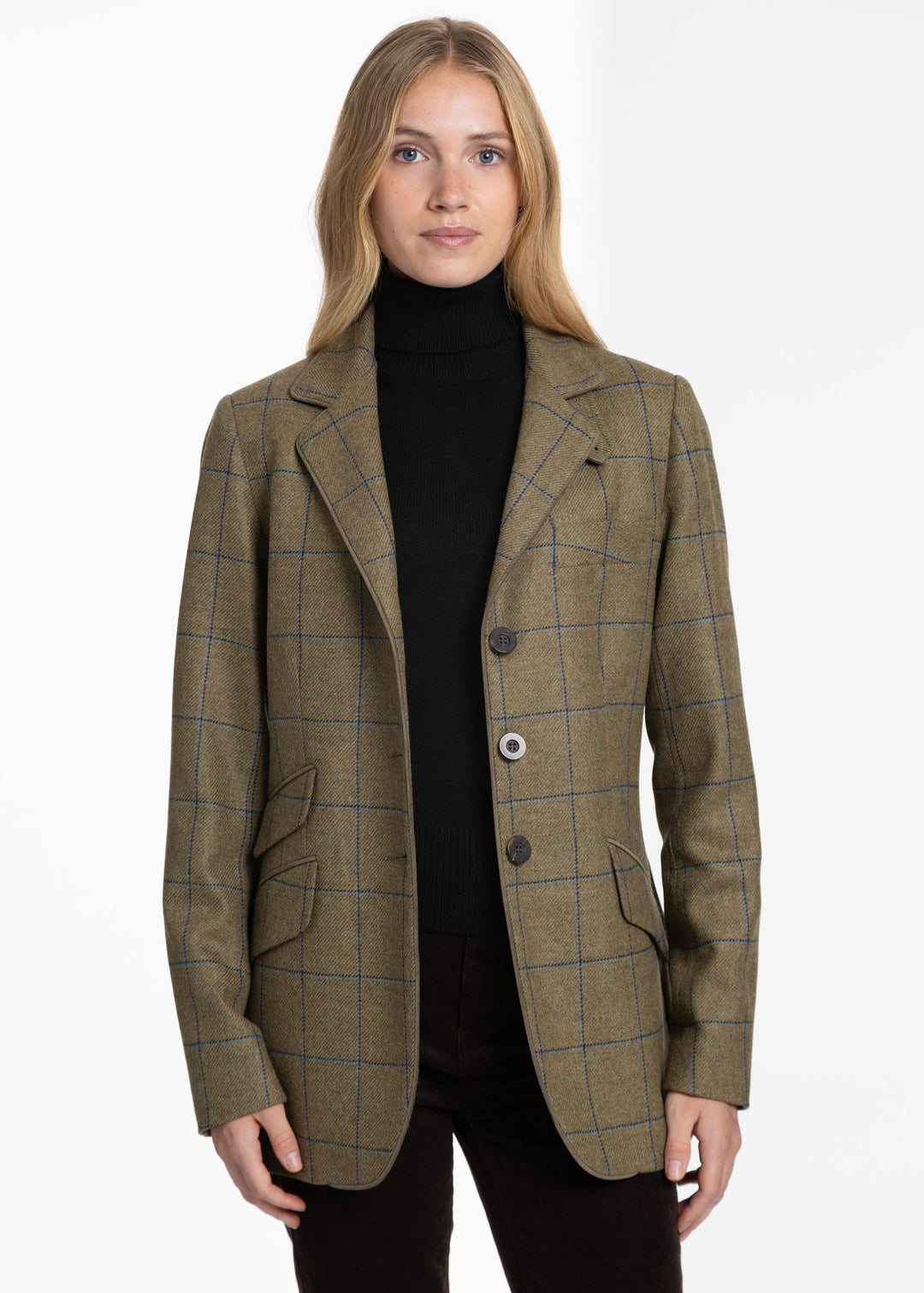 Woman wearing a green jacket with blue windowpane check pattern over a black turtleneck sweater.