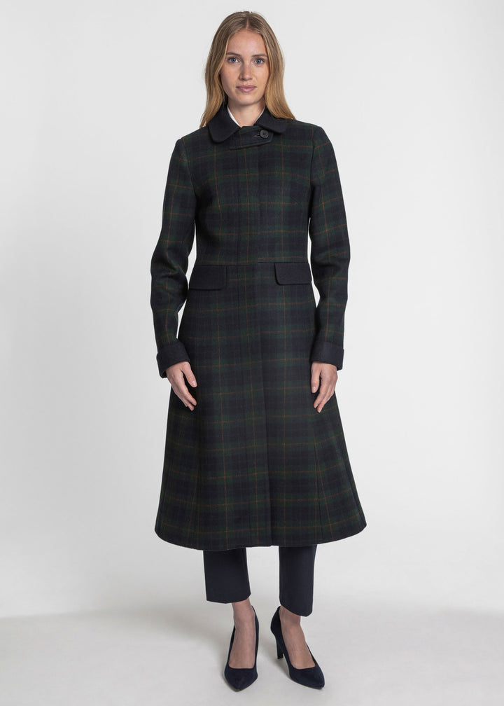 Woman wearing a navy and green plaid coat with navy contrasting accents.
