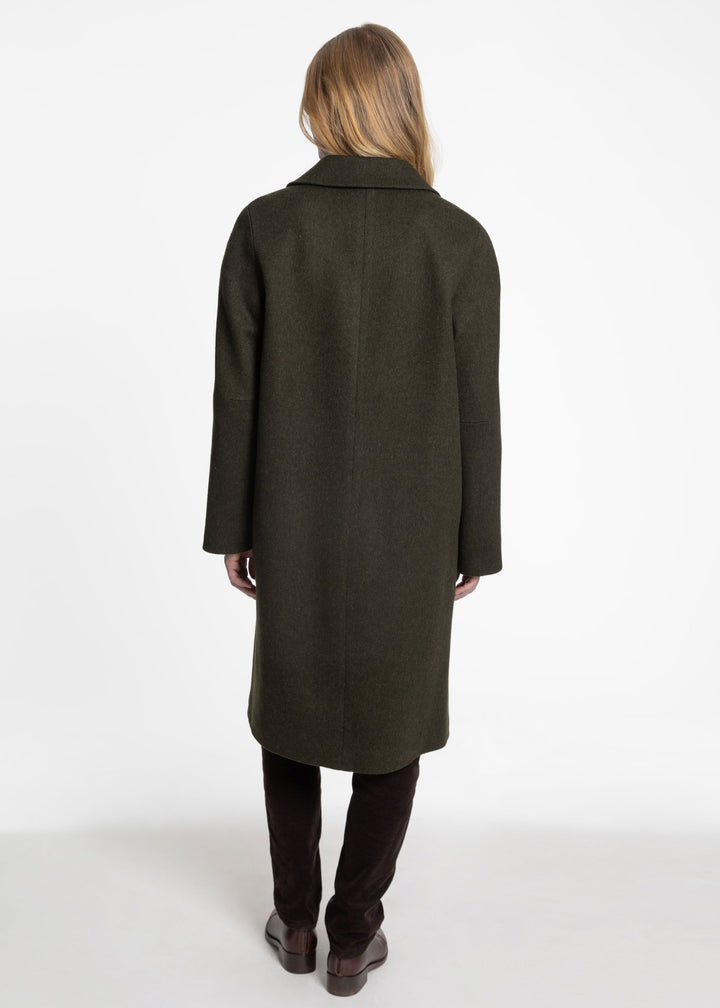 Back view of a woman wearing a dark green wool coat.