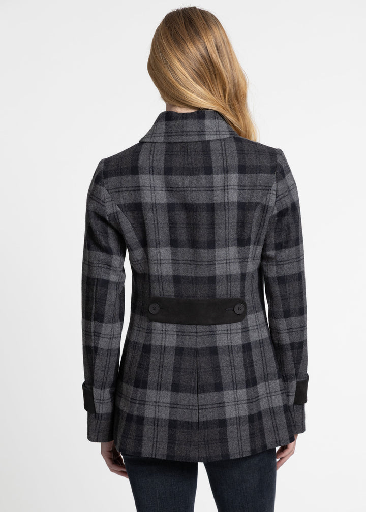A woman viewed from the back wearing a dark gray and black plaid jacket with a black waist belt and button details, paired with dark jeans against a plain white background.