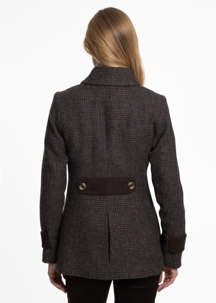 A woman viewed from the back wearing a dark brown and black plaid blazer with a contrasting dark brown waist belt and button details, set against a plain white background.