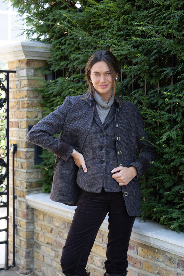 A woman wearing a matching black and brown check waistcoat and jacket.