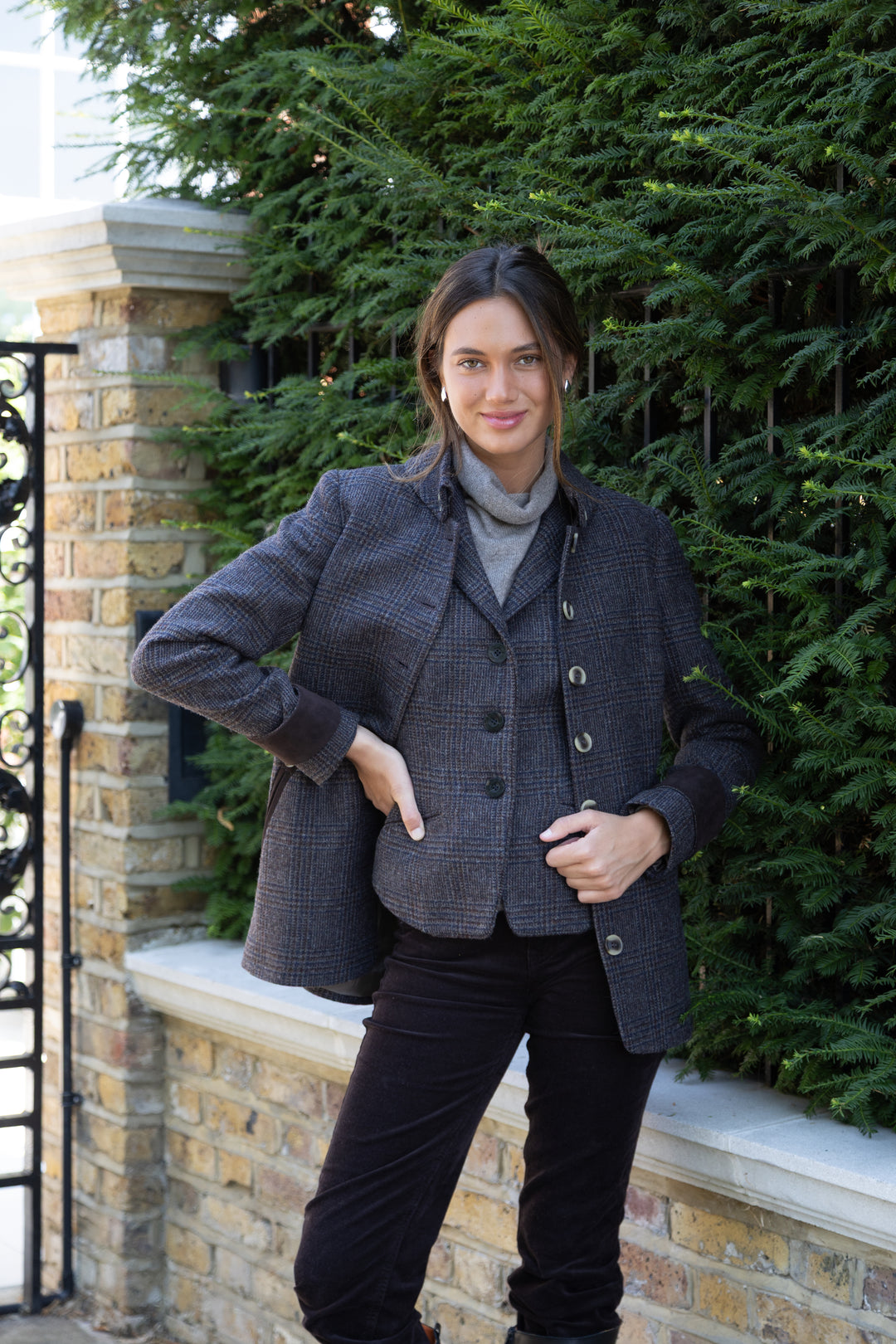 A woman wearing a matching black and brown check waistcoat and jacket.
