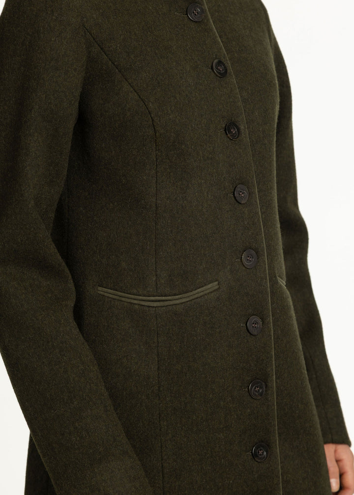 Close-up of an olive green wool-blend coat with dark buttons and a welt pocket, shown on a model against a white background.