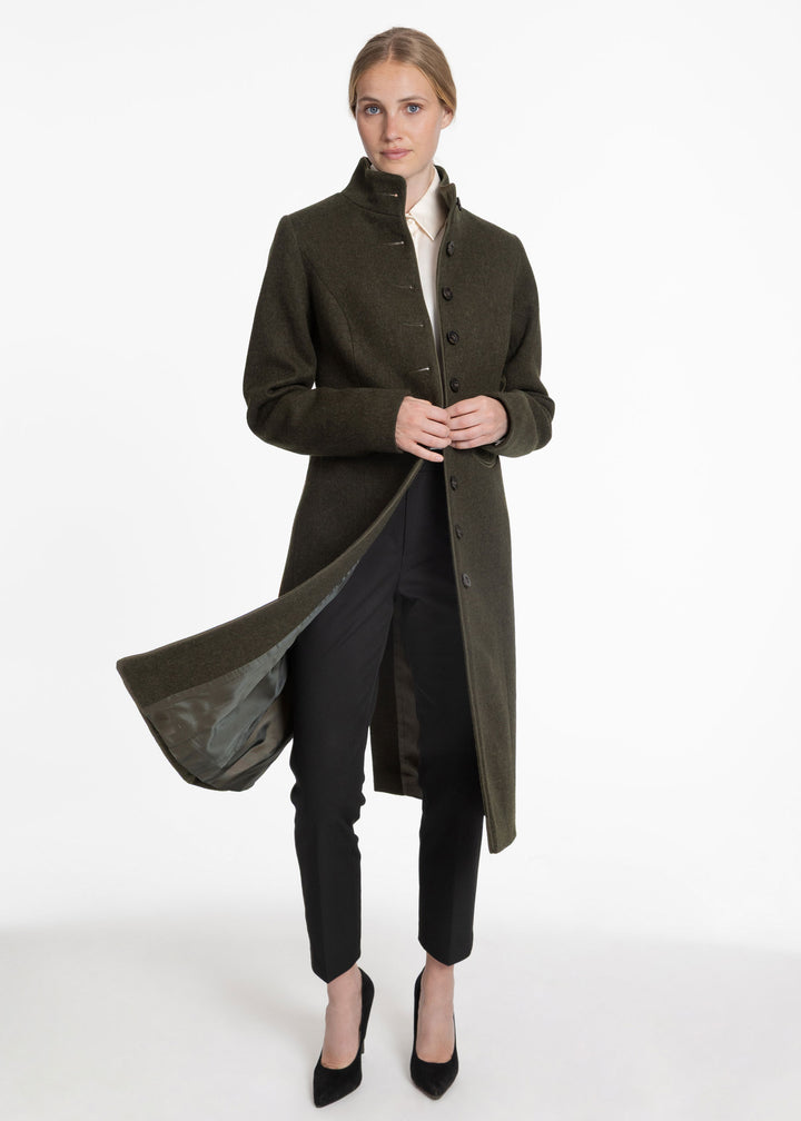 Woman wearing an olive green coat that swings open to show a green lining