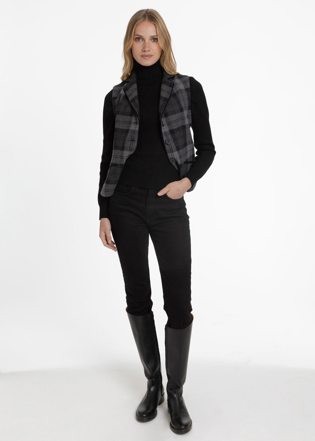 Woman modeling a black and grey plaid waistcoat over a black turtleneck.