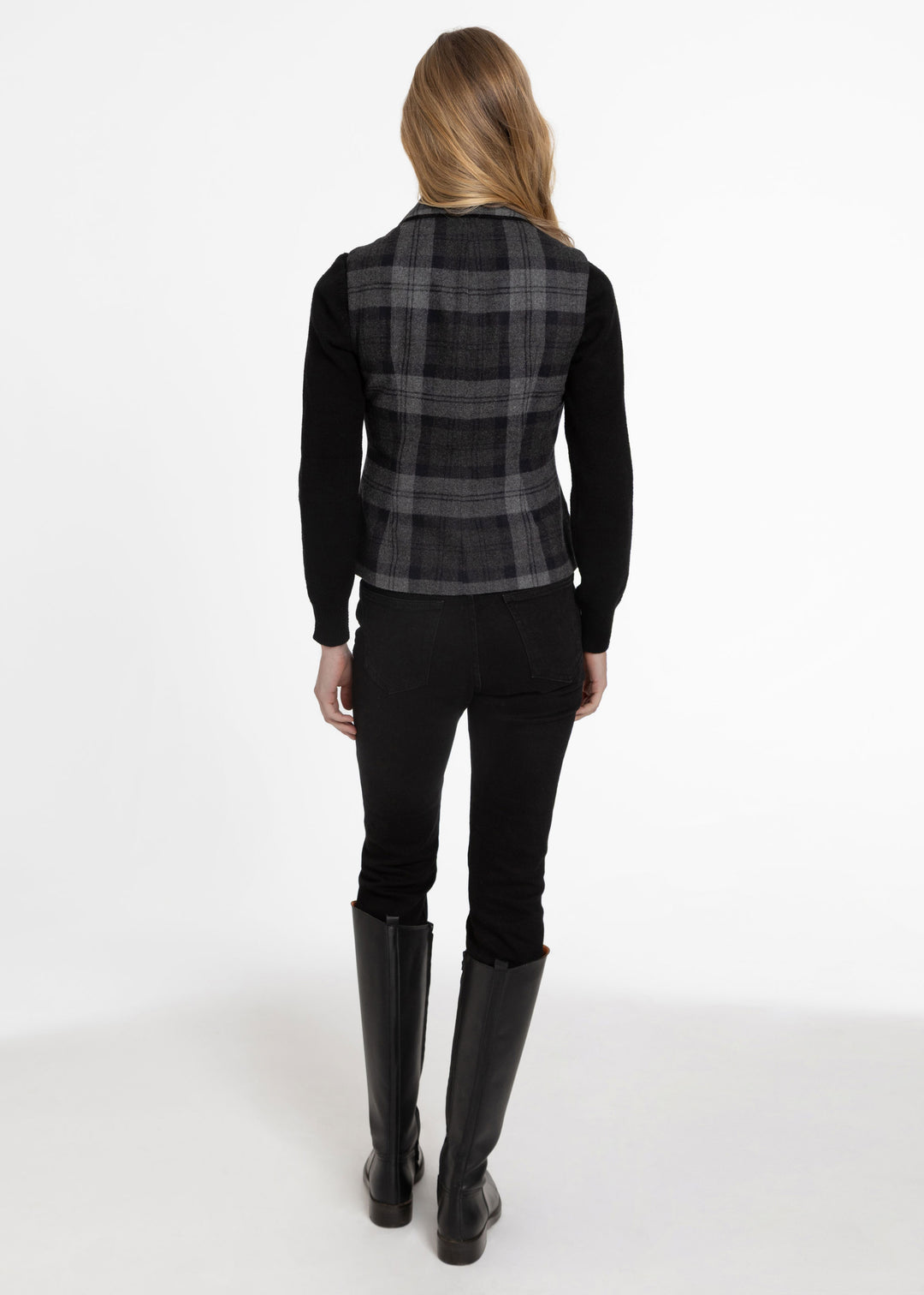 Back view of a woman wearing a black and grey plaid waistcoat.
