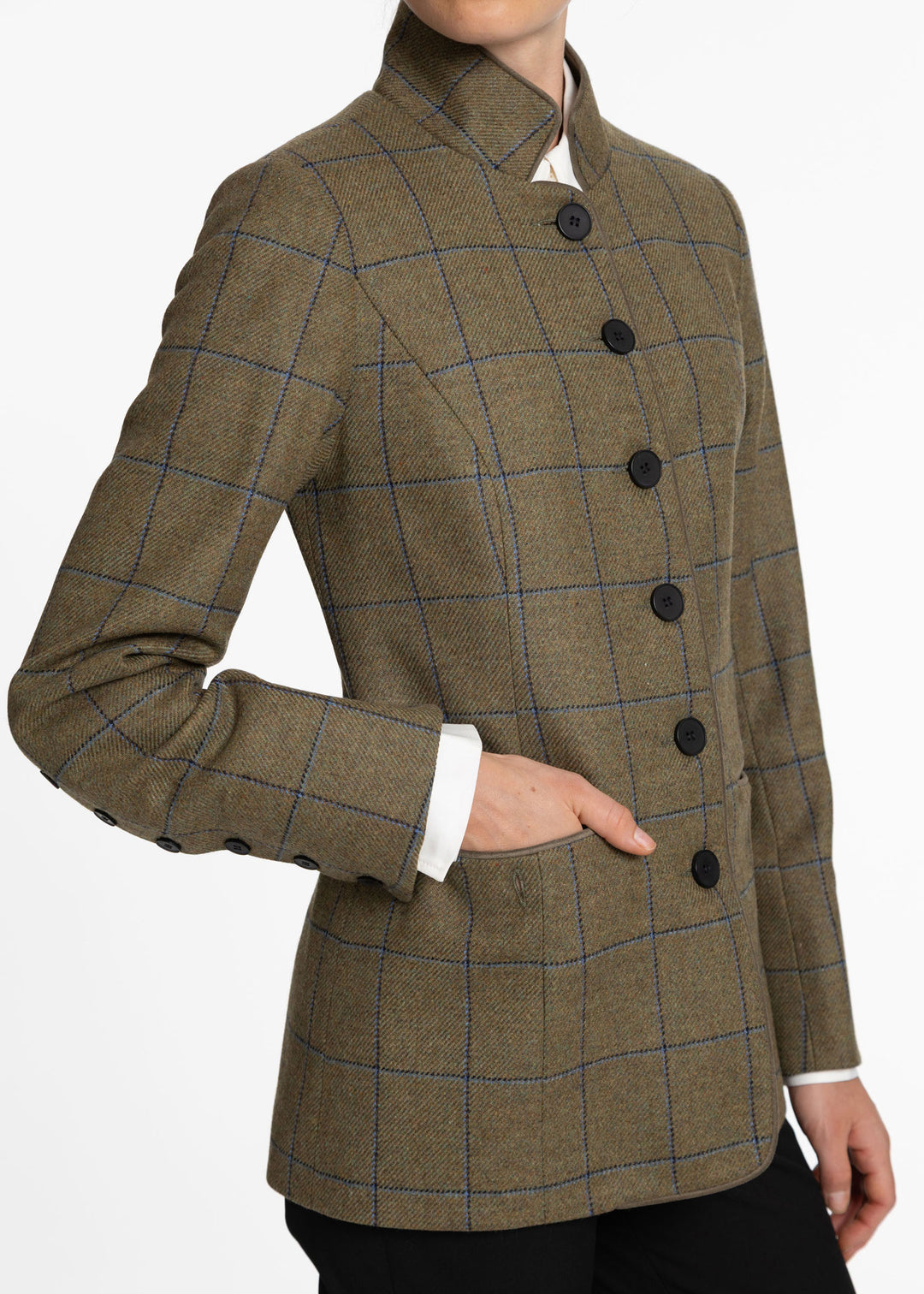 A cropped view of a person wearing a tailored jacket with a high stand collar, dark buttons, and a green and blue windowpane plaid pattern over a white collared shirt.