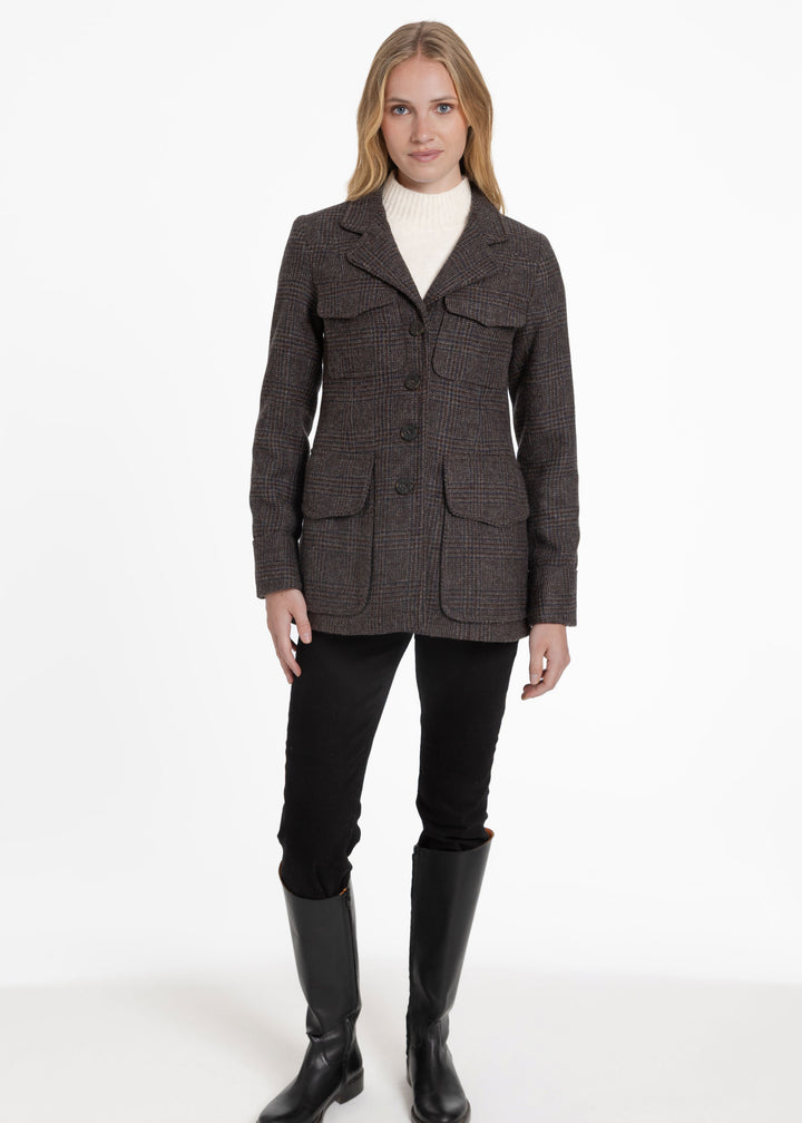Woman wearing brown and black utility style jacket with four front pockets.