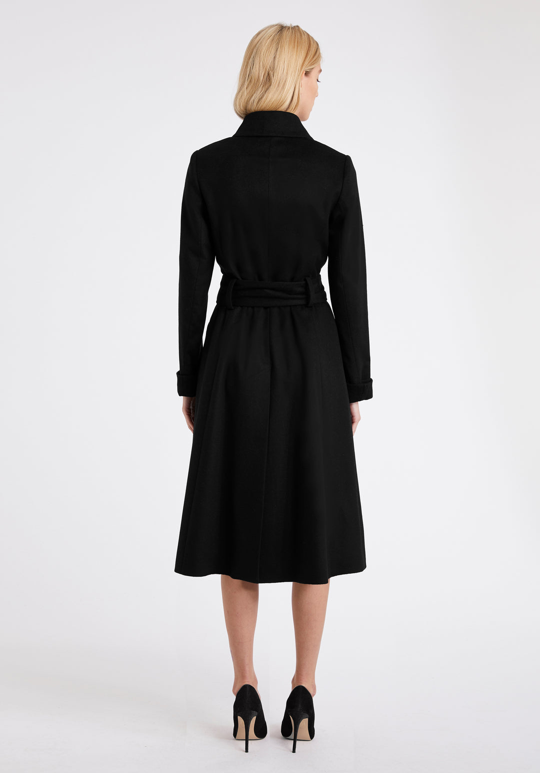 A model wears the Belted coat in black wool cashmere, featuring a slim fit with waist-cinching belt, deep turn-back cuffs and generous back vent.