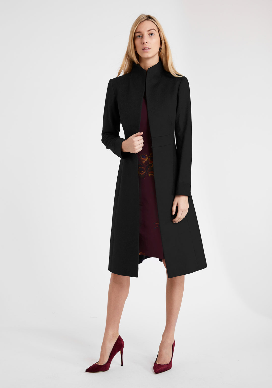 A model wears the Buxton coat in black wool cashmere, an elegant occasionwear style featuring a standing collar and deep suede cuffs.