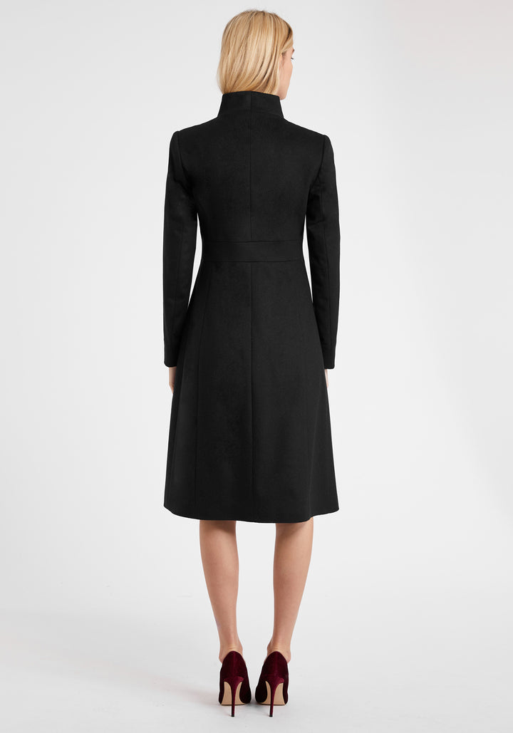 A model wears the Buxton coat in black wool cashmere, an elegant occasionwear style featuring a standing collar and deep suede cuffs.